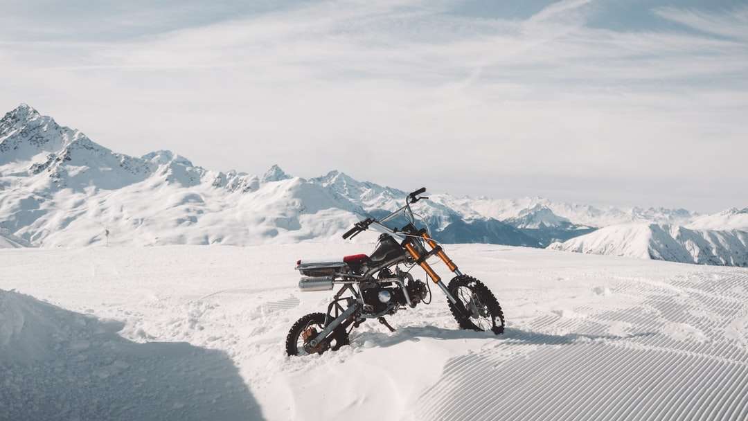 Hombre montando motocross dirt bike en campo cubierto de nieve rompecabezas en línea