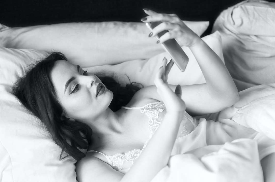 kvinna i vit blommig klänning som ligger på sängen pussel på nätet
