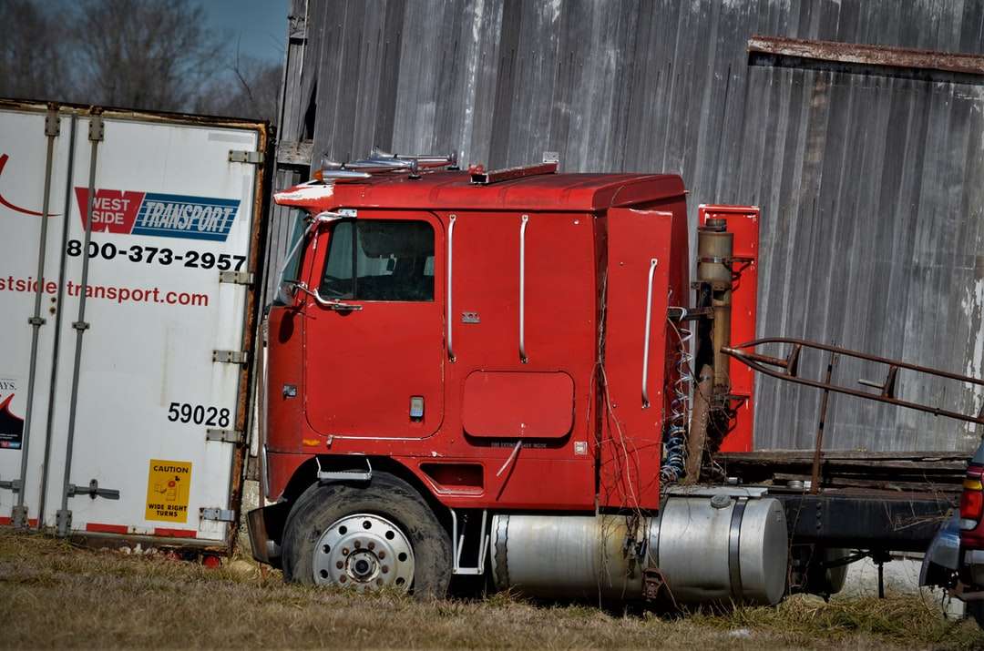 червен и бял товарен камион на поле със зелена трева онлайн пъзел