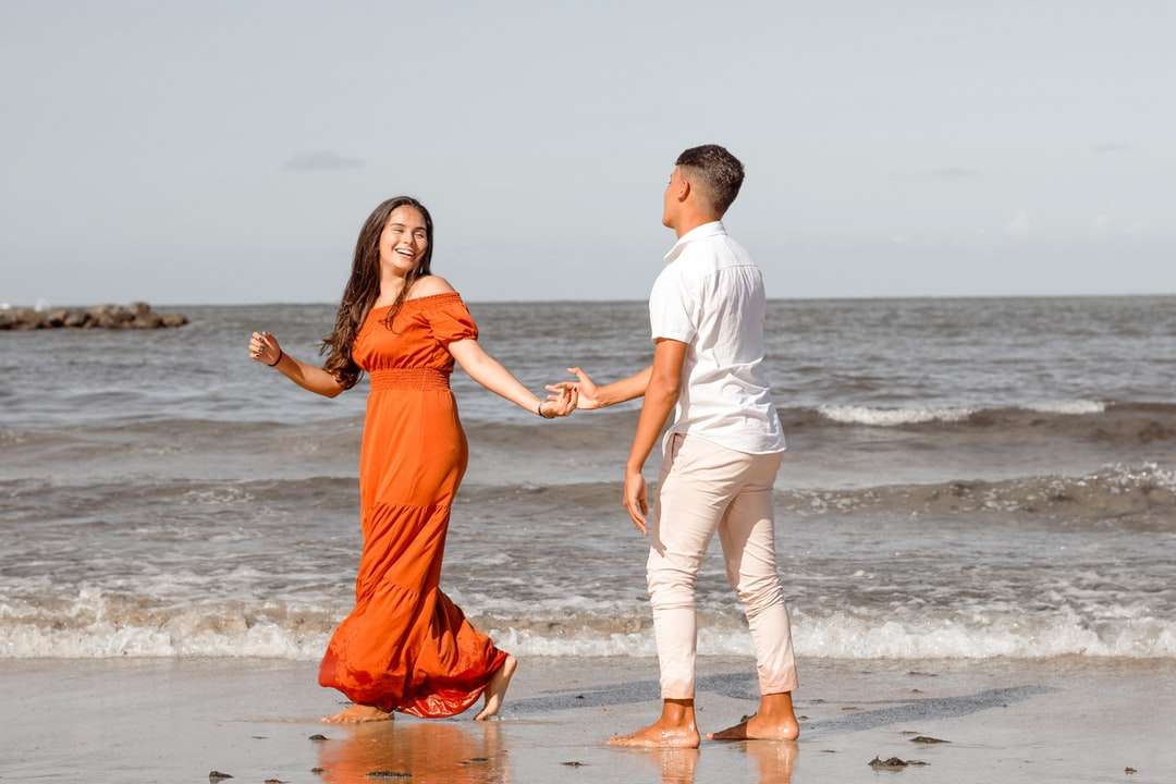 bărbat și femeie ținându-se de mână în timp ce merg pe plajă puzzle online