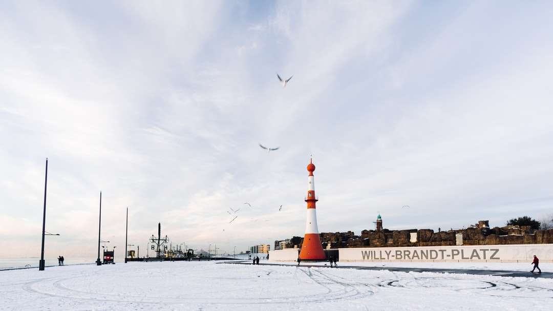 brauner und weißer Leuchtturm auf schneebedecktem Boden Puzzlespiel online