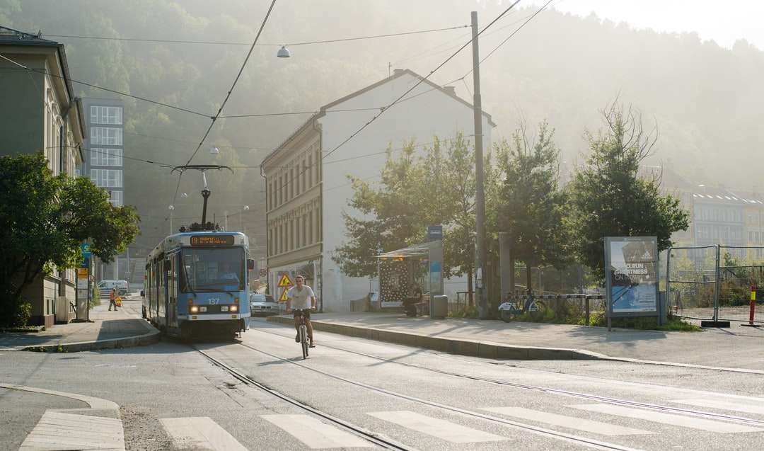 синьо-білий трамвай на дорозі біля будівлі в денний час онлайн пазл