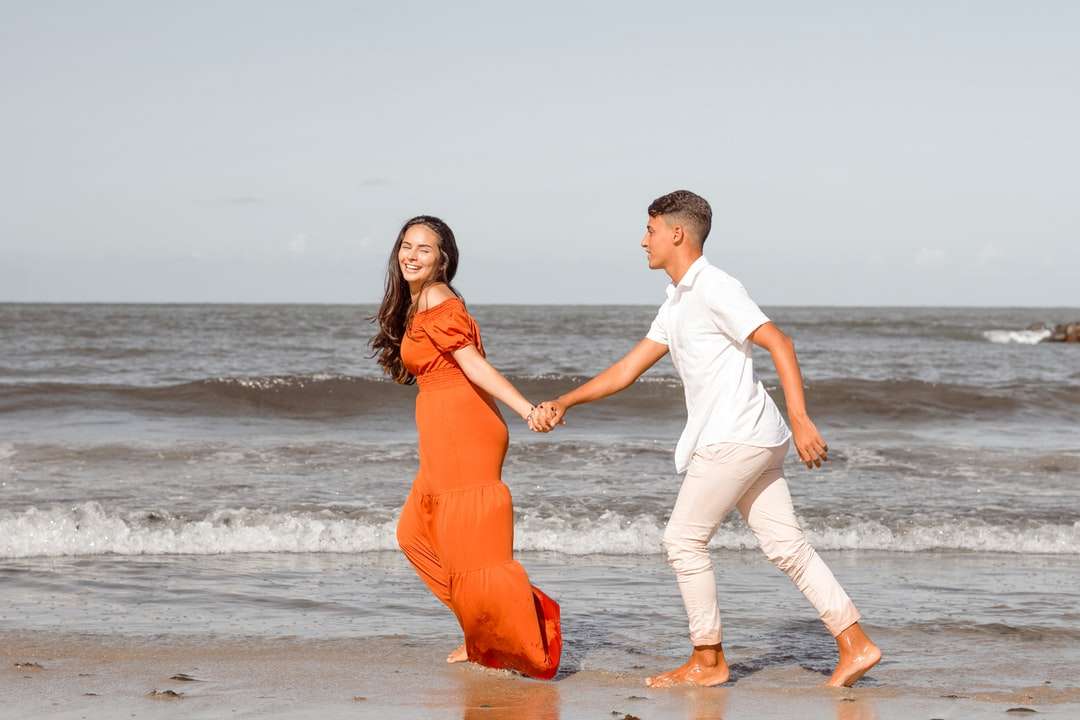 hombre y mujer en camisa blanca de manga larga y vestido naranja rompecabezas en línea