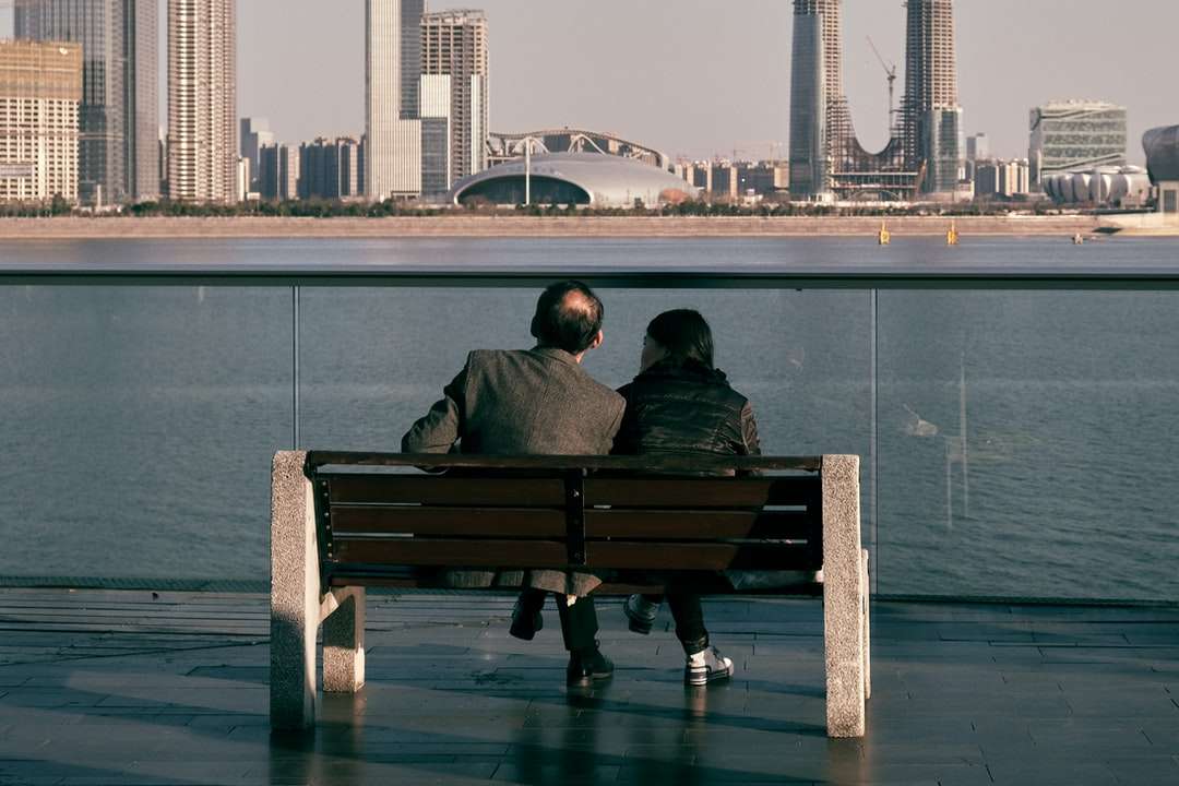 muž a žena sedící na hnědé dřevěné lavici skládačky online