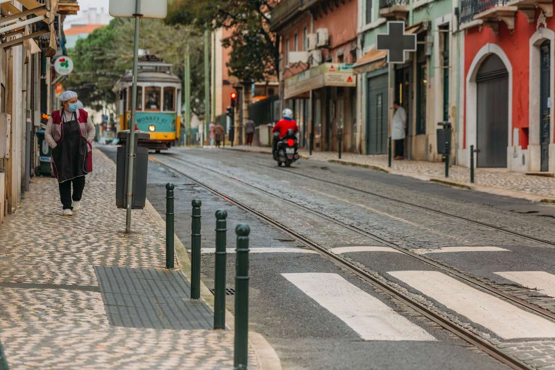 pessoa de jaqueta preta andando de bicicleta na calçada quebra-cabeças online
