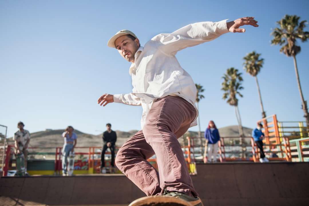 homem de camisa branca de manga comprida e calça marrom pulando puzzle online