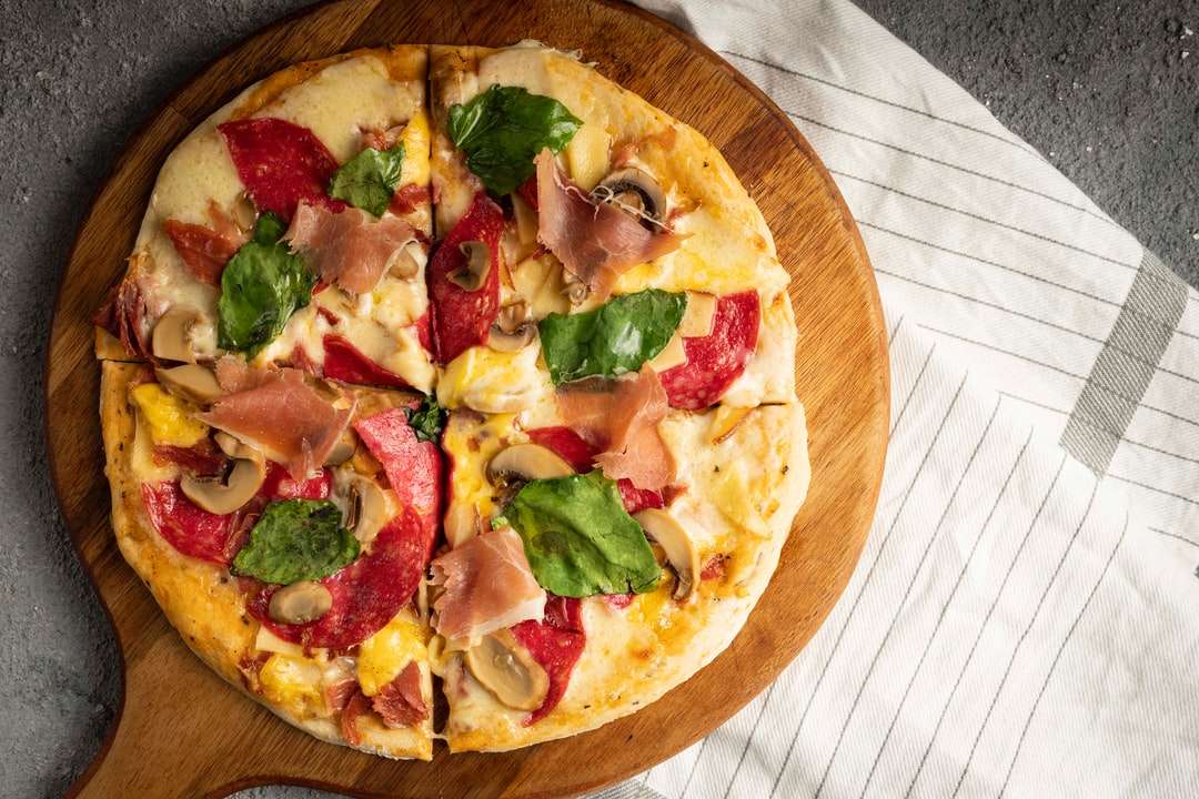 Pizza mit grünem und rotem Paprika und grünen Blättern Online-Puzzle