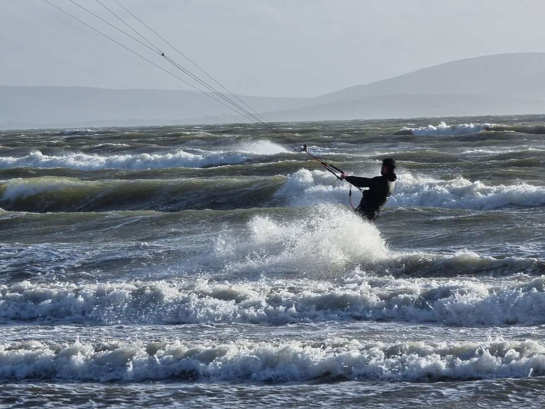 человек занимается серфингом на морских волнах в дневное время онлайн-пазл