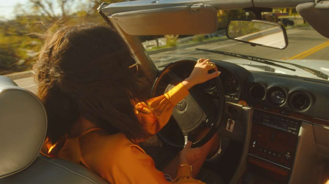 Frau im orangefarbenen Hemd, das Auto fährt Puzzlespiel online