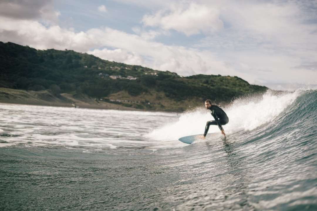 Hombre surfeando en el mar durante el día rompecabezas en línea