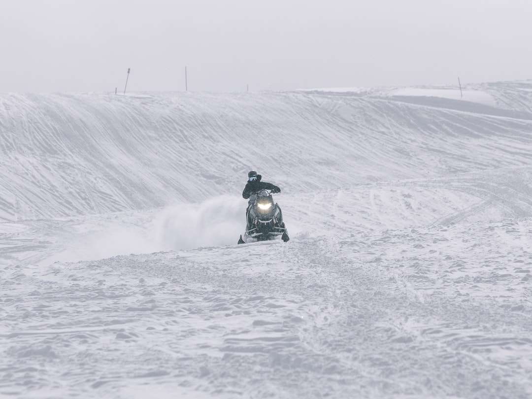 persoon rijden op zwarte motorfiets op sneeuw bedekt veld legpuzzel online