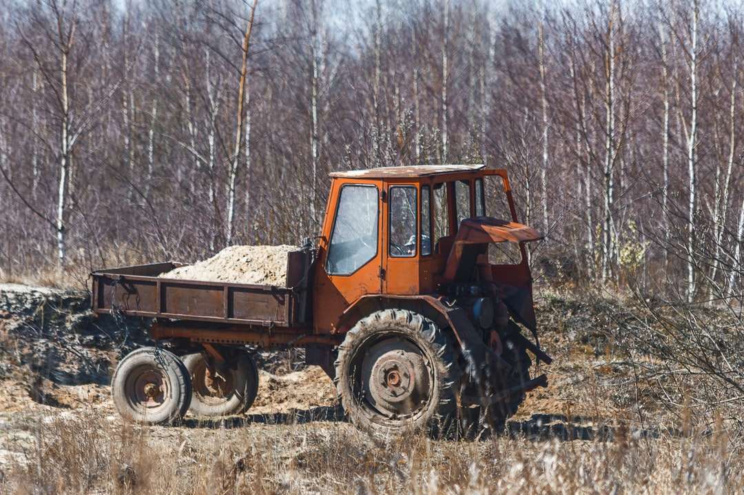 orange und schwarzer Traktor auf braunem Grasfeld während des Tages Online-Puzzle
