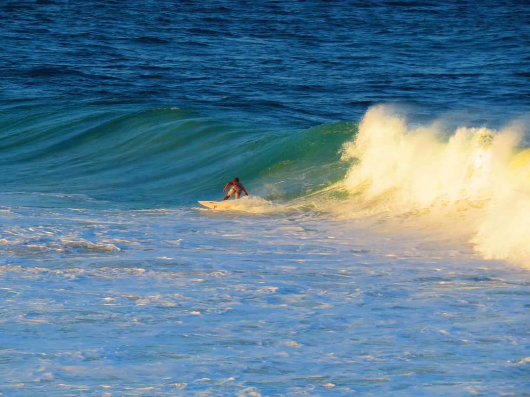 άντρας σερφ στα κύματα της θάλασσας κατά τη διάρκεια της ημέρας online παζλ