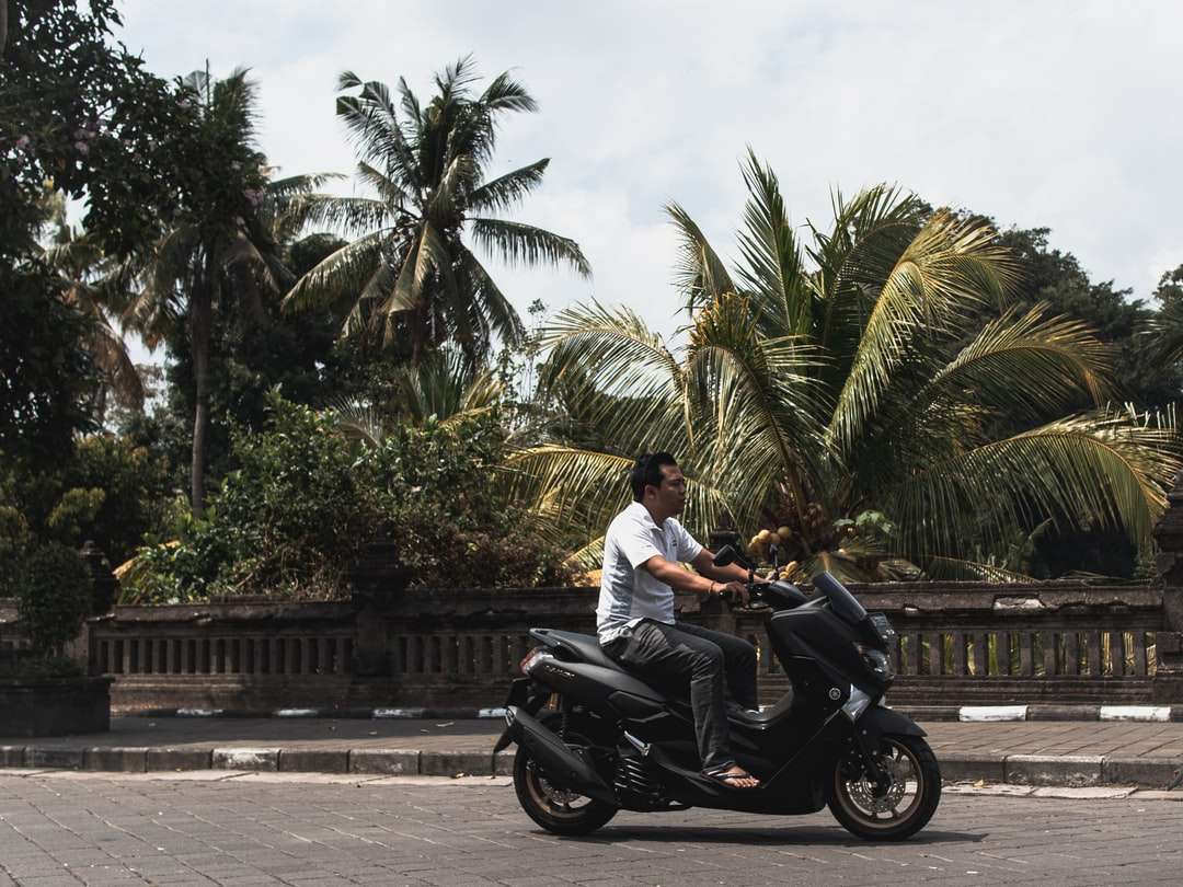 道路で黒いオートバイに乗っている白いシャツの男 ジグソーパズルオンライン