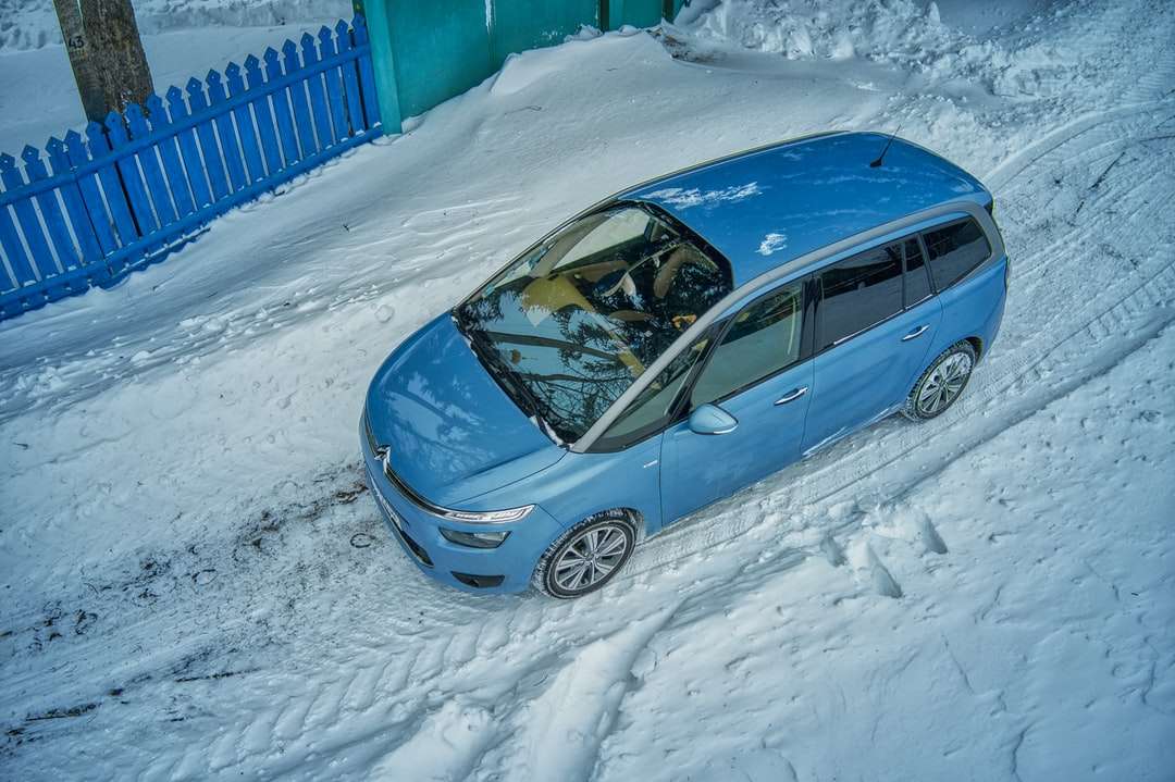 hatchback azul de 5 puertas en la carretera cubierta de nieve durante el día rompecabezas en línea