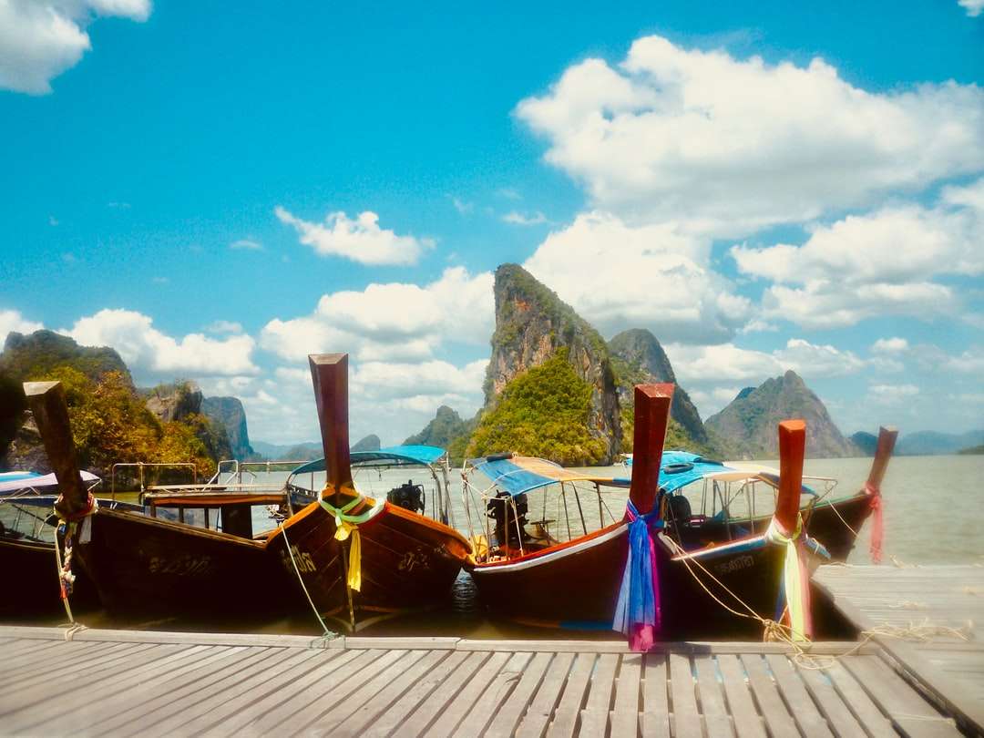 коричневий дерев'яний човен на доку в денний час пазл онлайн