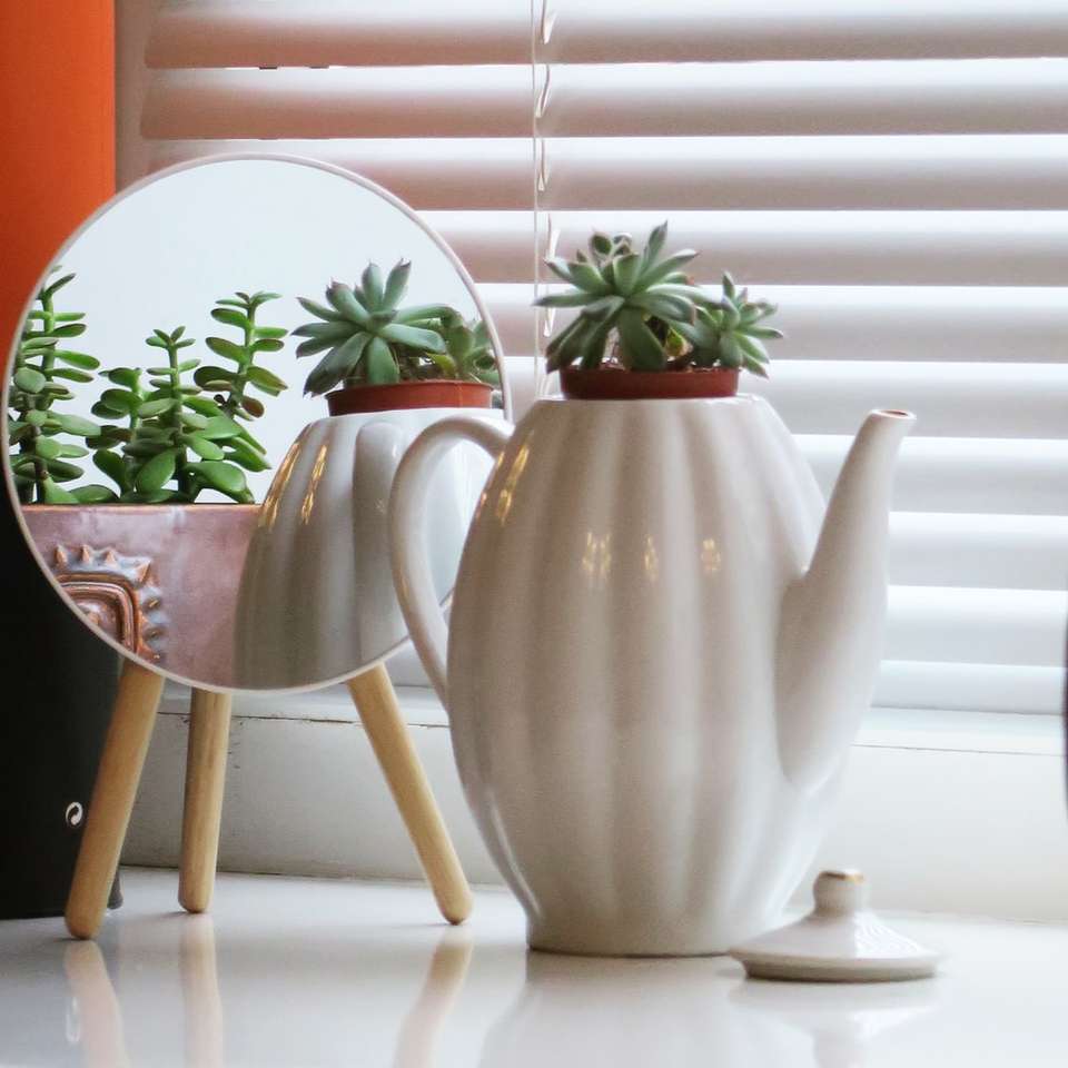 бял керамичен чайник със зелено растение върху кафява дървена маса онлайн пъзел