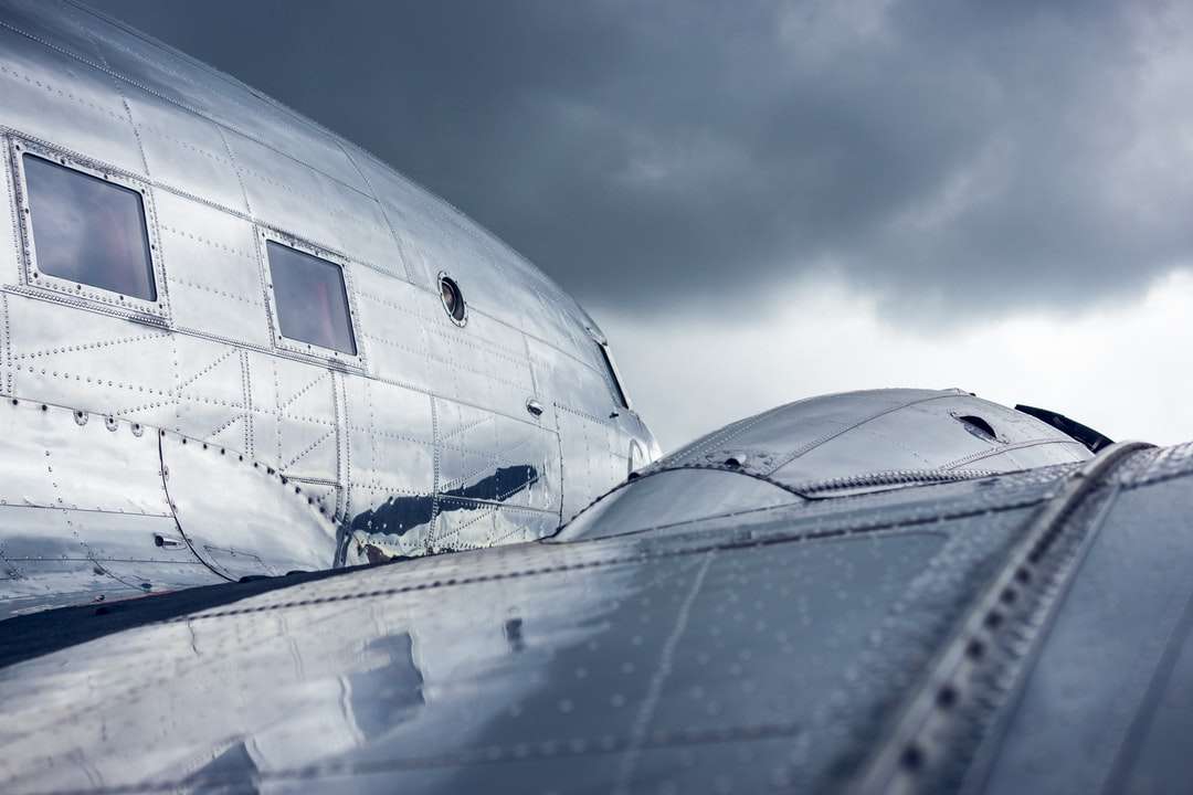 aeroplano bianco sotto il cielo nuvoloso durante il giorno puzzle online