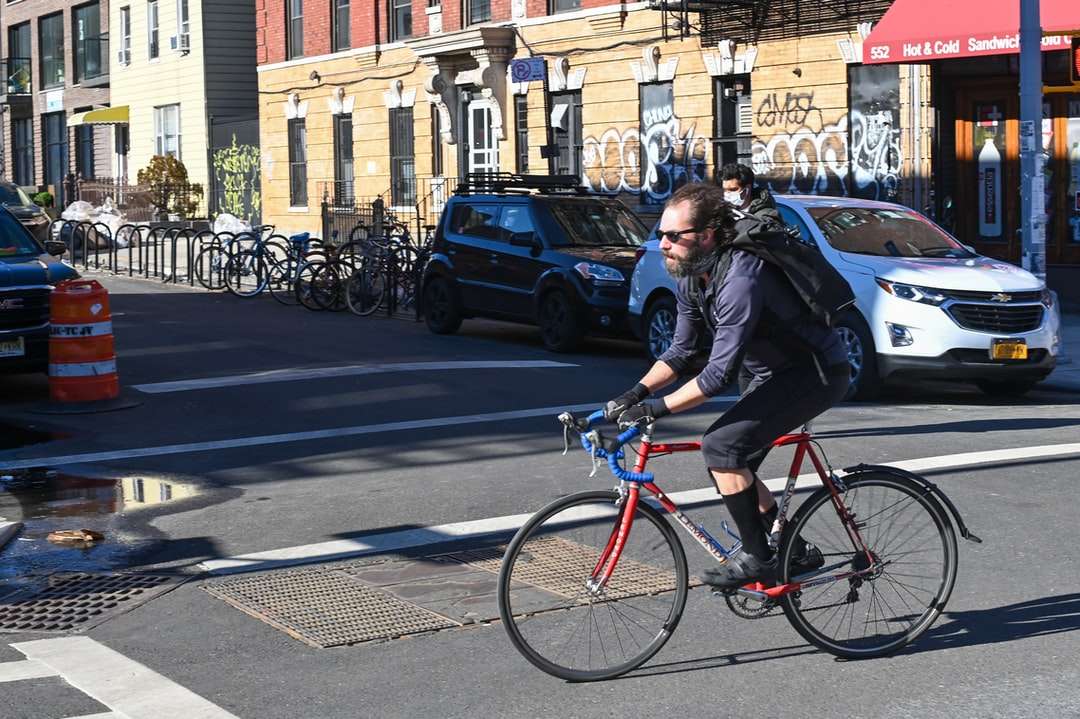 道路で赤い自転車に乗って黒いジャケットの男 オンラインパズル