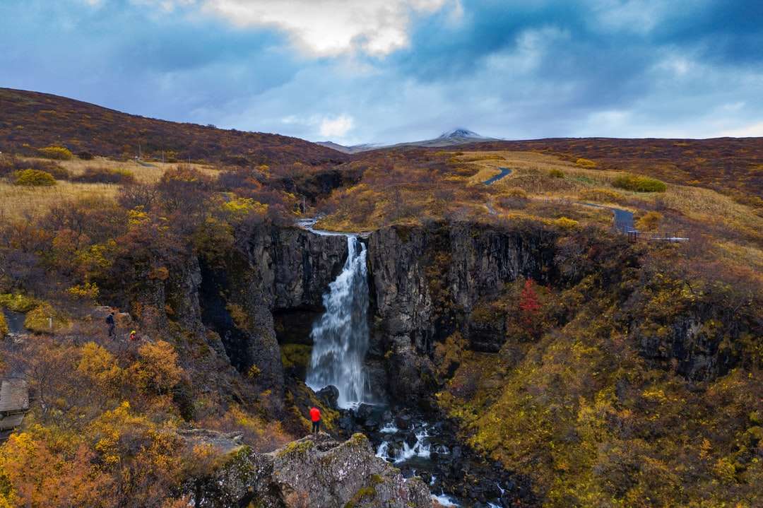 watervallen op bruine rotsachtige berg onder witte bewolkte hemel online puzzel