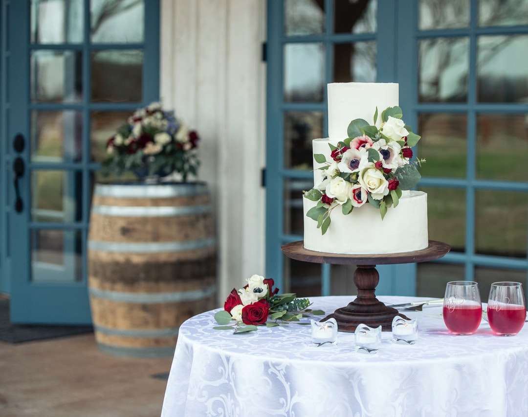 vit och rosa blommig tårta på brunt träbord Pussel online