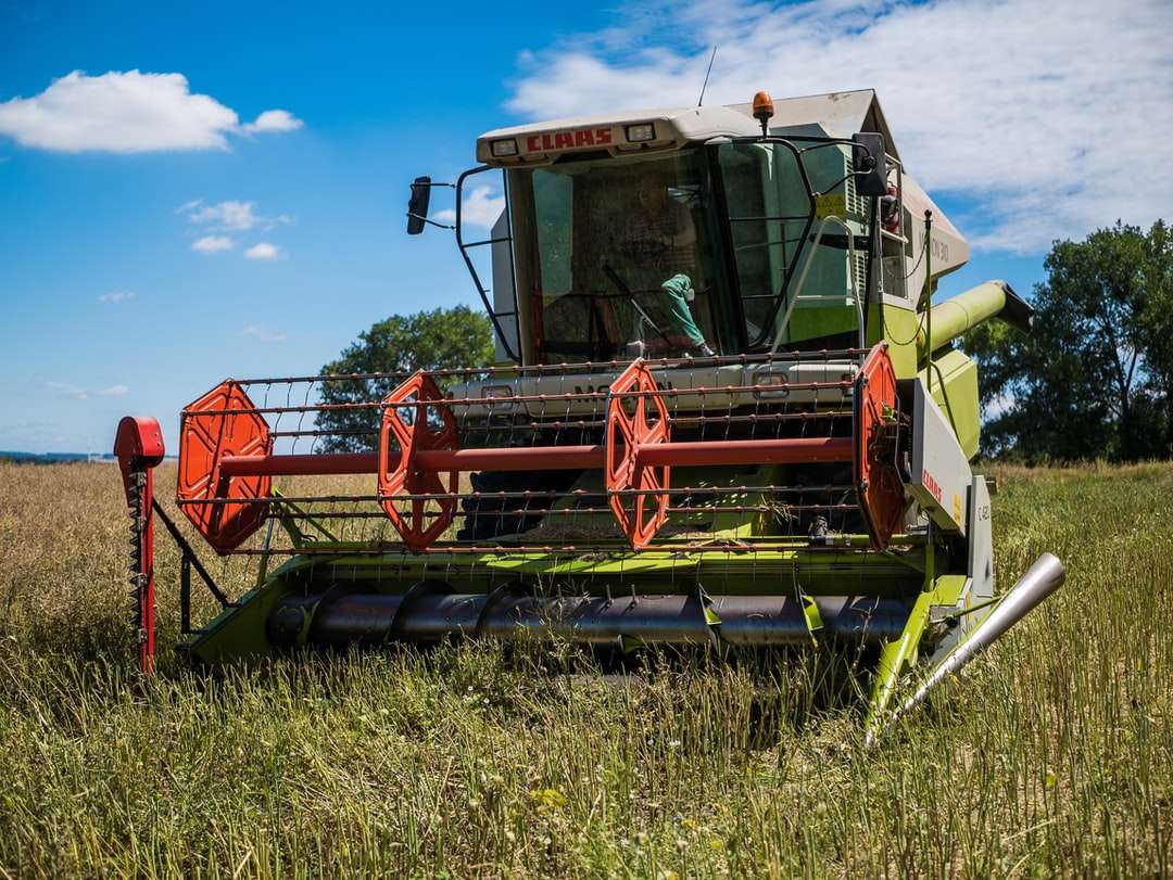 röd och grön tung utrustning på fältet för grönt gräs Pussel online