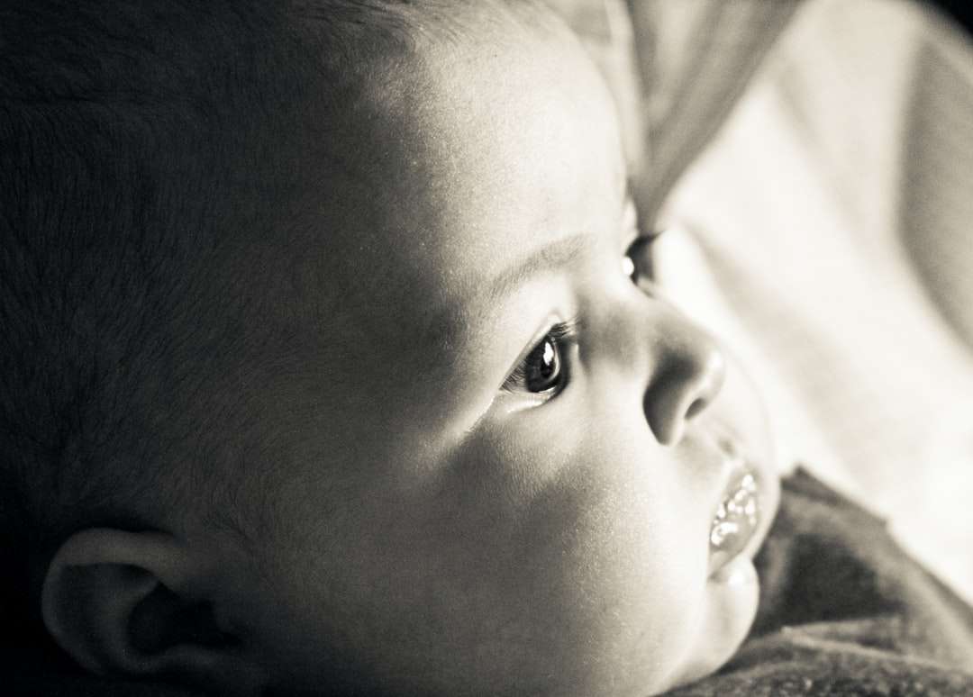 grijswaardenfoto van baby liggend op bed legpuzzel online
