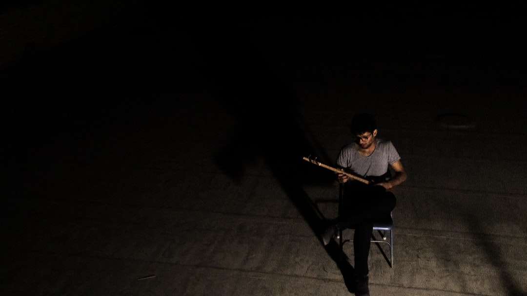 muž v šedém tričku s výstřihem do krku hraje na kytaru skládačky online