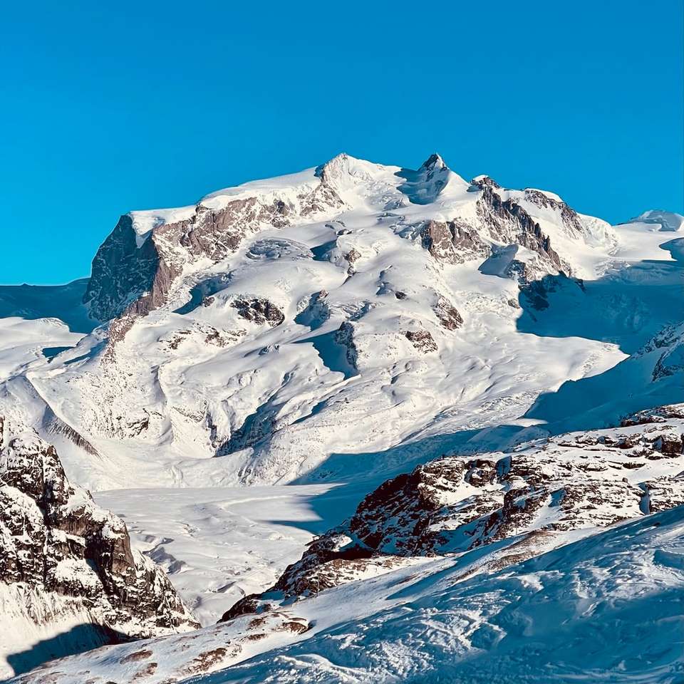 snow covered mountain under blue sky during daytime jigsaw puzzle online