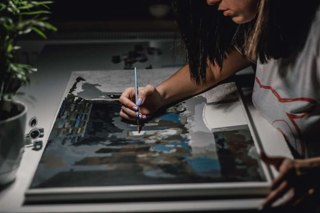 mujer pintando sobre papel blanco rompecabezas en línea
