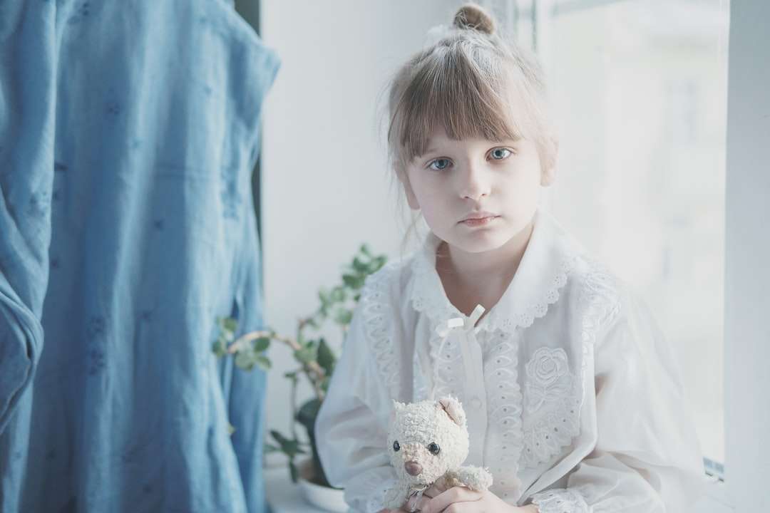 Девушка в белом платье держит плюшевую игрушку белого медведя пазл онлайн