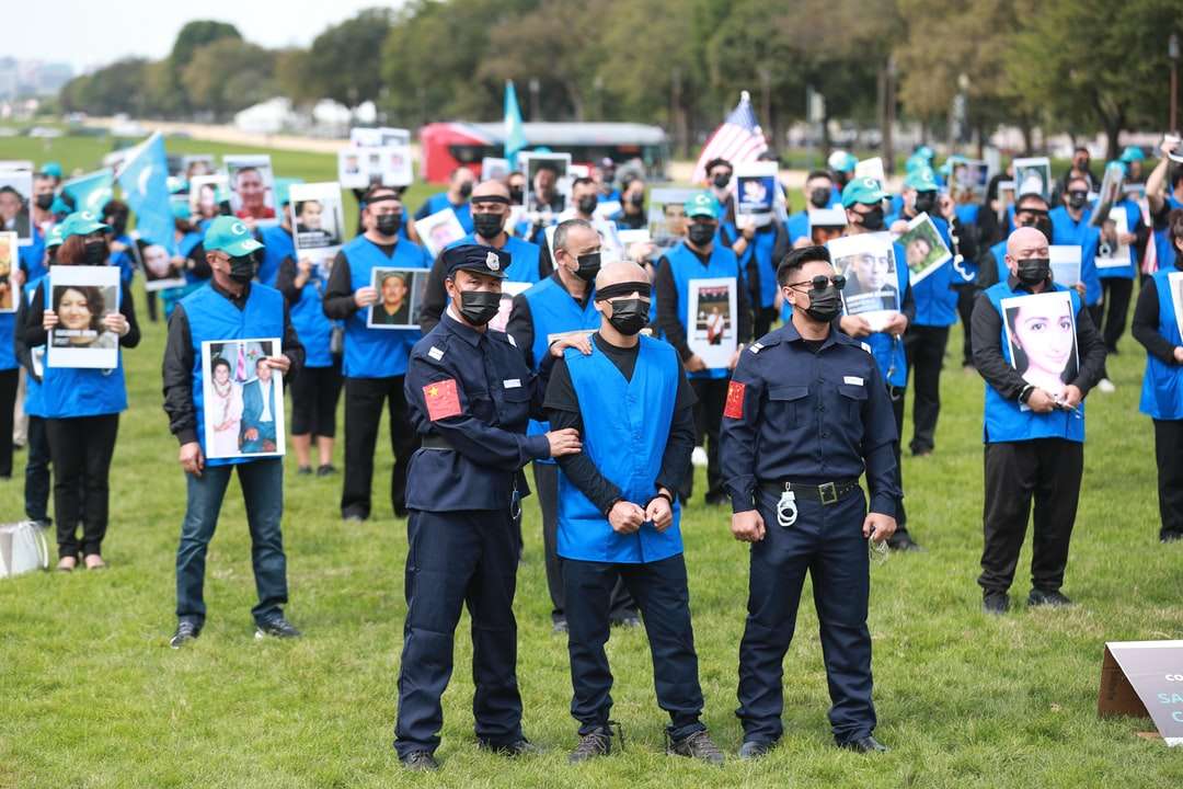 Mann in der blauen Polizeiuniform, die auf grünem Grasfeld steht Online-Puzzle