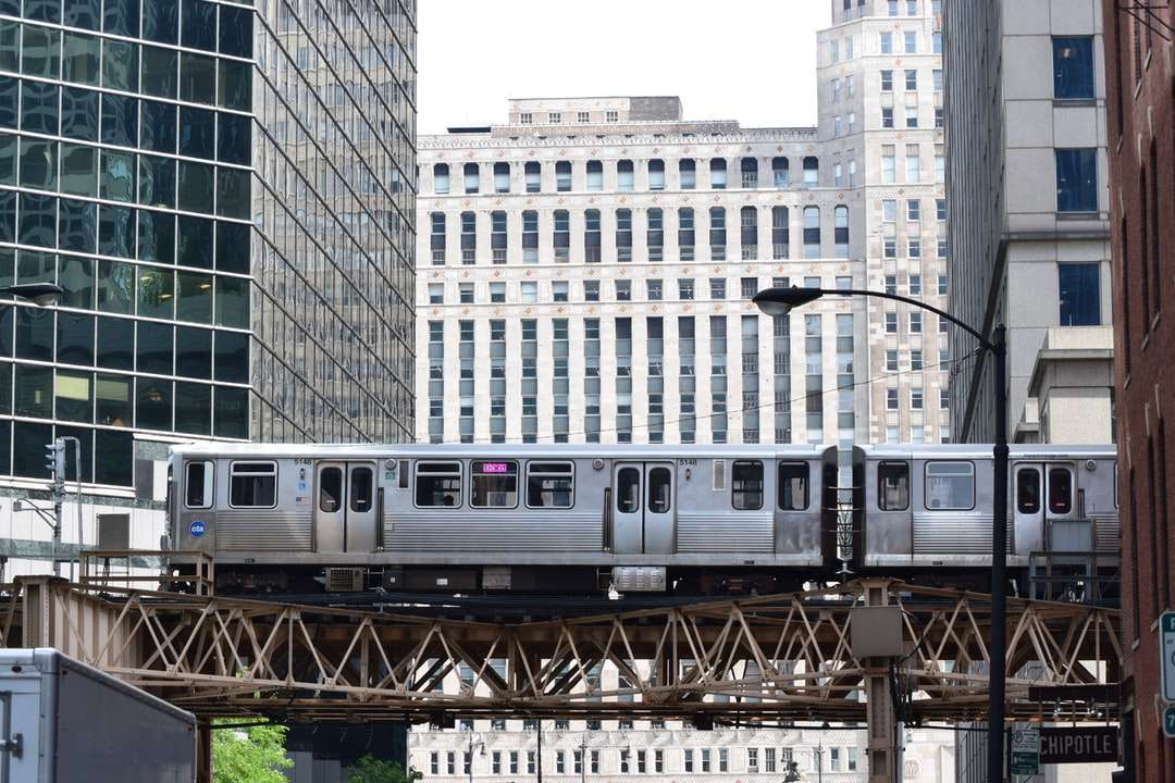 bílý vlak na železnici poblíž budovy během dne online puzzle