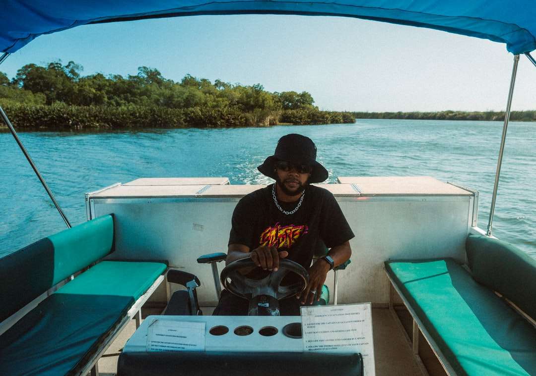 мъж в черно-жълта тениска на врата на екипажа, седнал на лодка онлайн пъзел