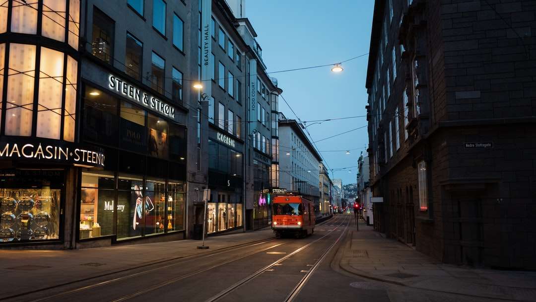 rote und weiße Straßenbahn auf der Straße in der Nähe des Gebäudes während des Tages Online-Puzzle