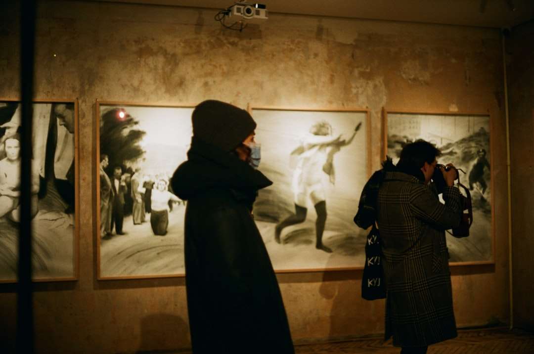 om în haina neagră stând în fața picturii puzzle online