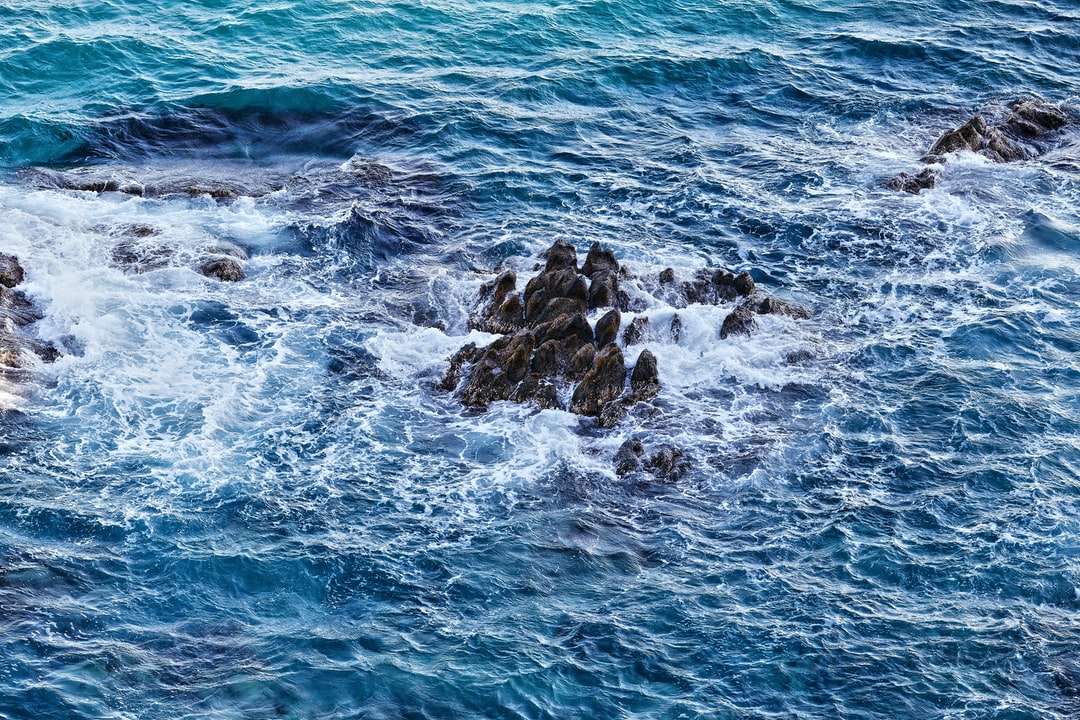 vlny oceánu narážející na kameny během dne online puzzle