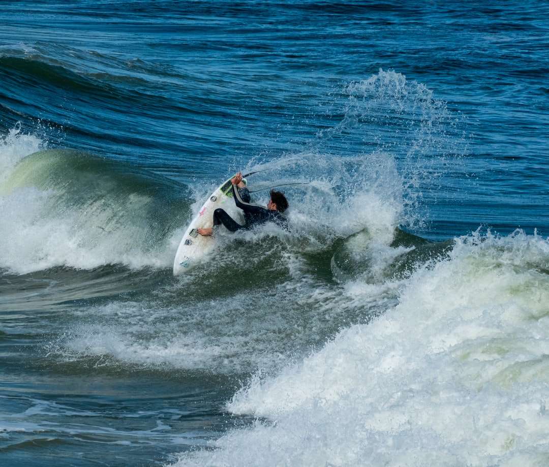 Hombre surfeando sobre las olas del mar durante el día rompecabezas en línea