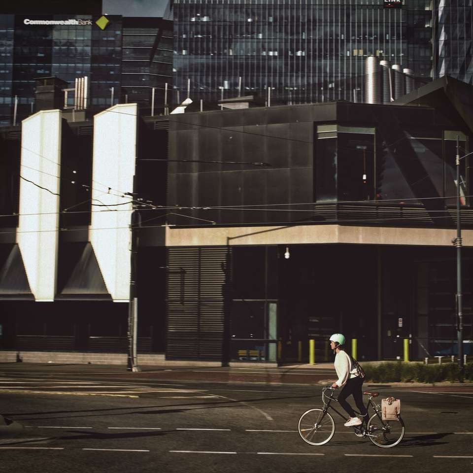 man in black shirt riding bicycle on road near building online puzzle