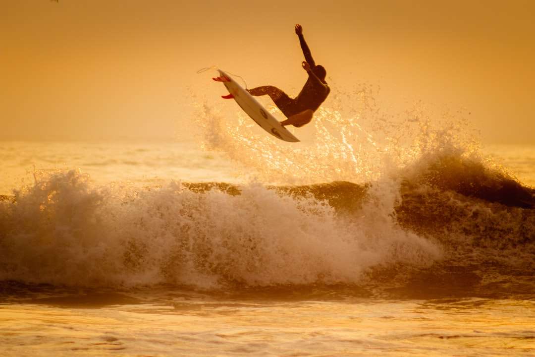 людина серфінг на морських хвилях вдень онлайн пазл