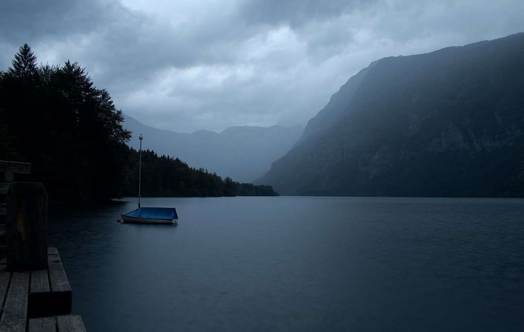 синя лодка по водоема близо до планината през деня онлайн пъзел