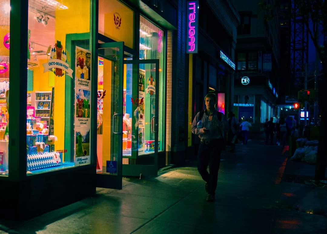 om în geacă neagră mergând lângă magazin puzzle online