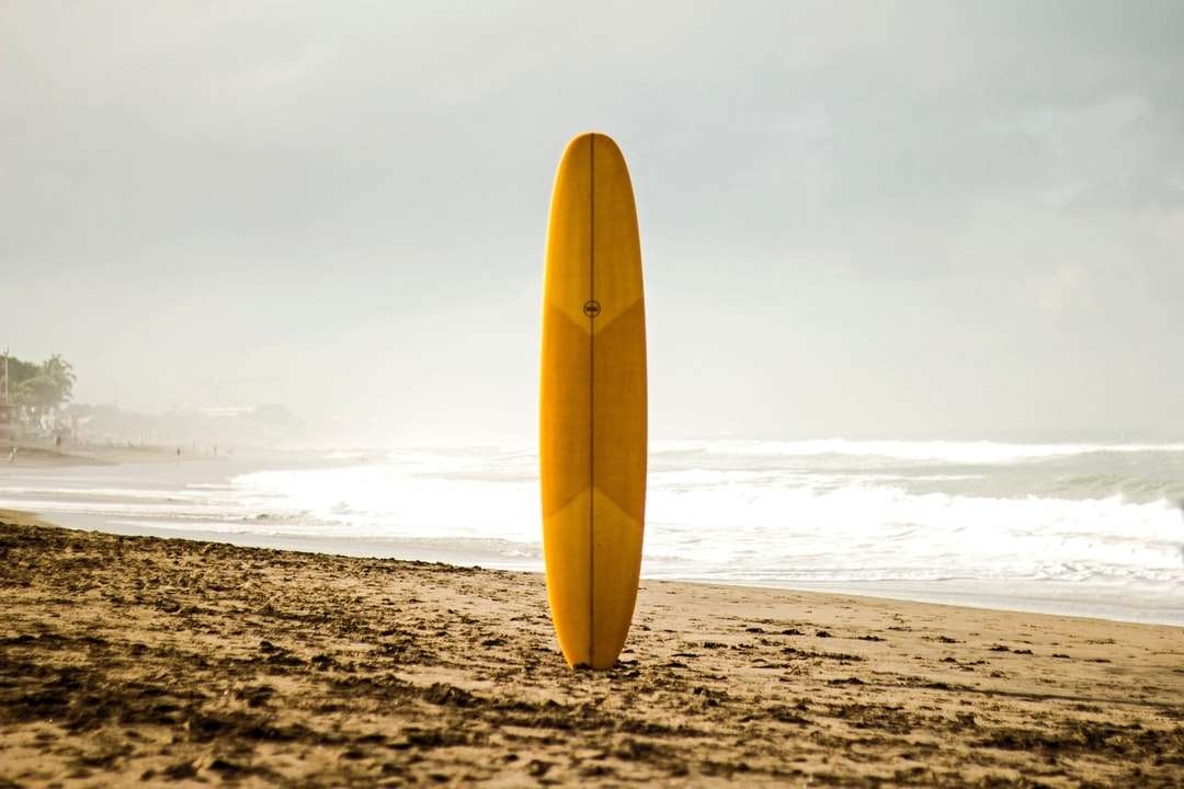yellow surfboard on beach shore during daytime online puzzle