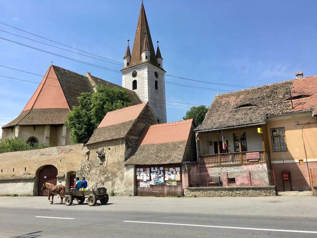 Проезжайте через деревню с запряженной лошадью телегой в Румынии. пазл онлайн