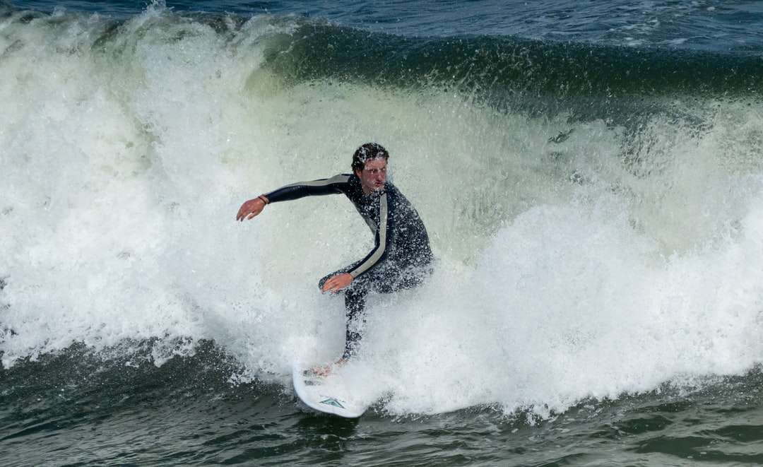 άντρας σερφ στα κύματα της θάλασσας κατά τη διάρκεια της ημέρας παζλ online
