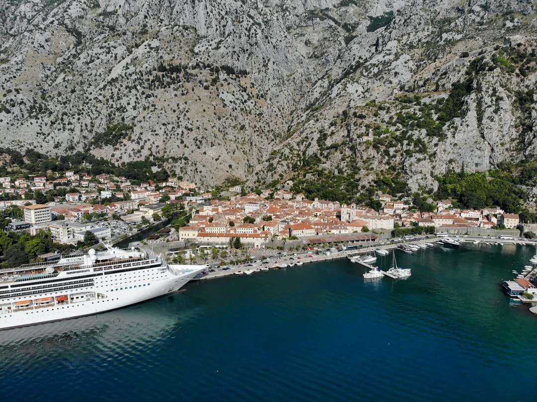 white cruise ship on body of water near mountain jigsaw puzzle online