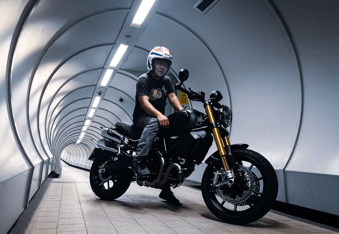 uomo in casco nero in sella a una moto nera puzzle online