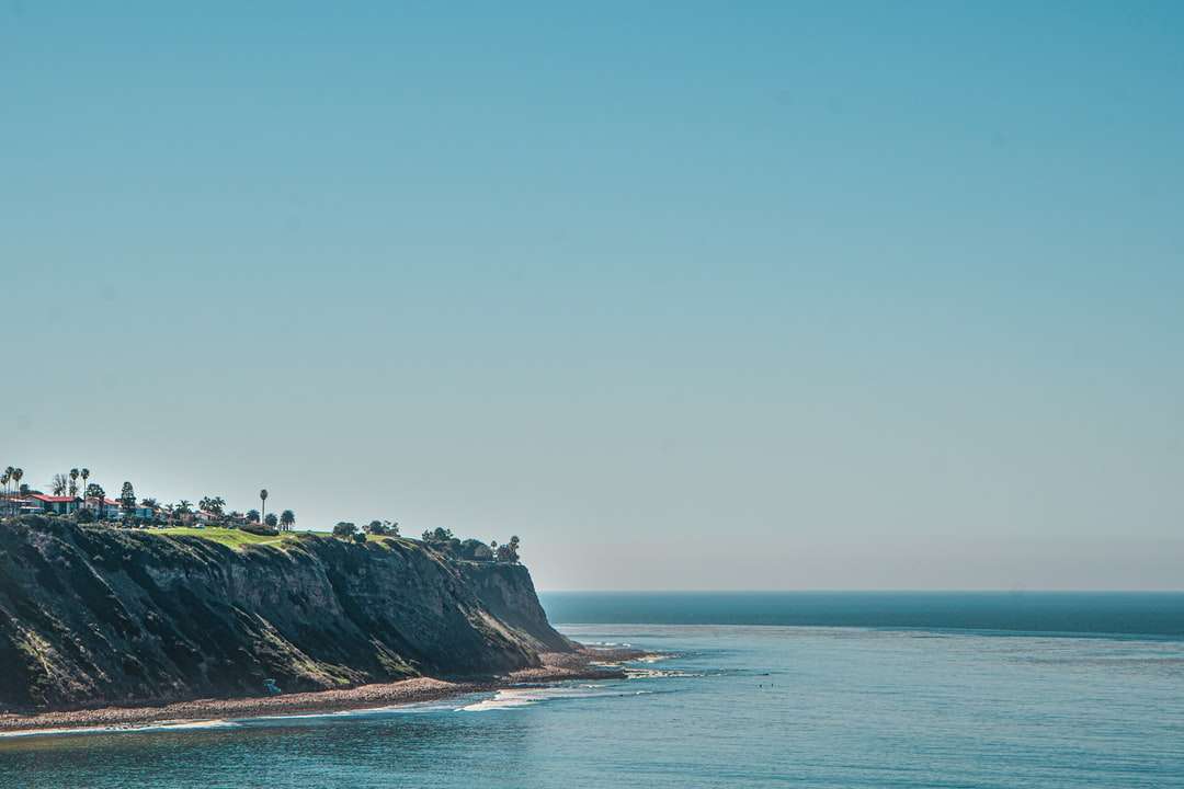 personnes debout sur une falaise au bord de la mer pendant la journée puzzle en ligne