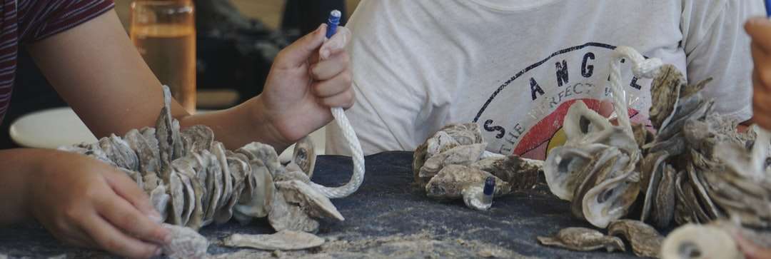 pessoa segurando uma corda branca na rocha cinza quebra-cabeças online