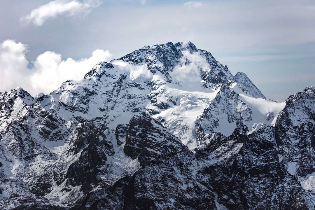 munte acoperit de zăpadă sub cer înnorat în timpul zilei puzzle online